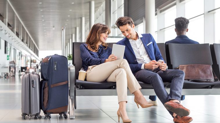 Business couple waiting for flight at airport lounge
